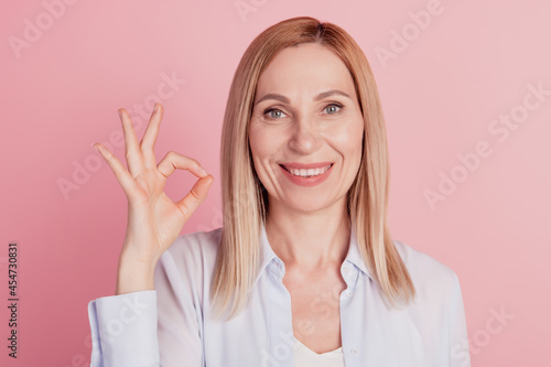 Vászonkép Close up portrait of sweet cute girl gesturing ok sign with fingers deal done al