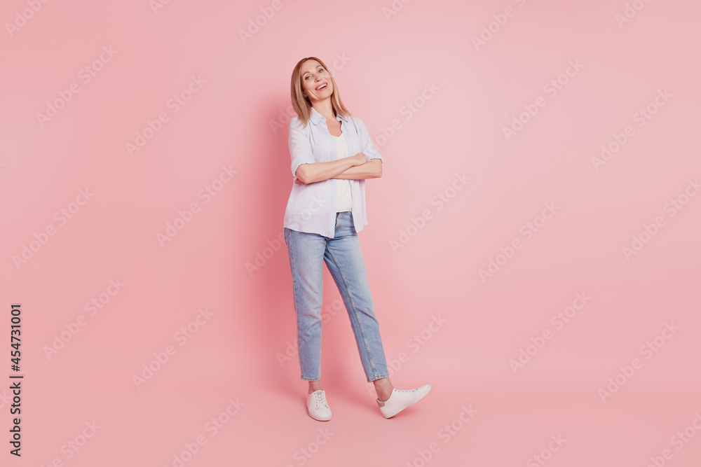Full body photo of youg attractive woman happy positive smile folded hands look empty space isolated over pink color background Full body photo of youg attractive woman happy positive smile folded hands look empty space isolated over pink color background