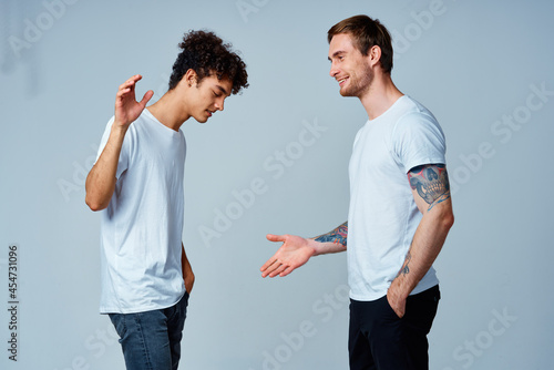 two men in t-shirts friendship communication light background