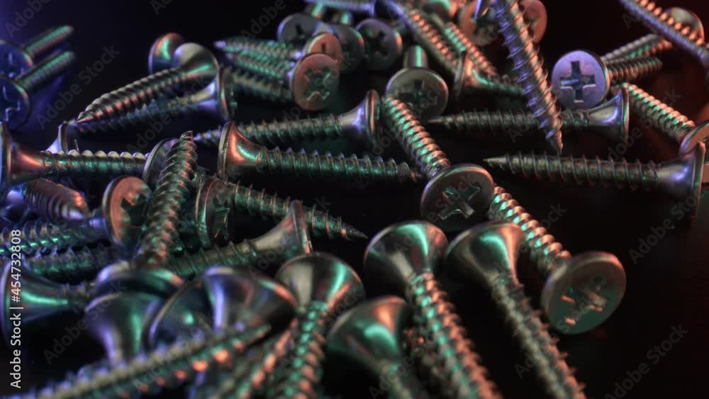A large magnet attracts several steel self-cutting screws from the table, close-up. Parts and materials for fastening and construction. High quality. 4k footage. A large magnet attracts several steel self-cutting screws from the table, close-up. Parts and materials for fastening and construction. High quality. 4k footage.