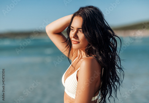 people, summer and swimwear concept - beautiful young woman in bikini swimsuit on beach
