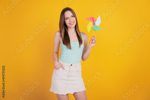 Portrait of charming childish cute lady hold toy propeller having fun on yellow background