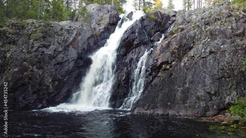 Close-up of Hepokongas waterfall in Kainuu, Finland. The flowing water from the huge rock shows the power of water and the beauty of falling water. 4k video photo