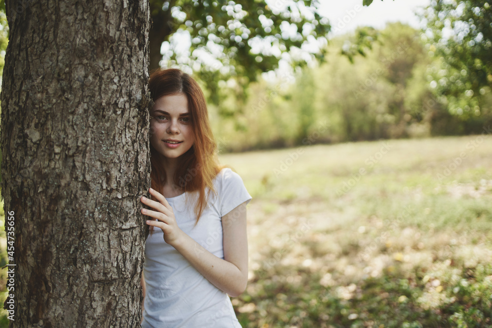 red-haired woman with bouquet of flowers nature trees summer vacation