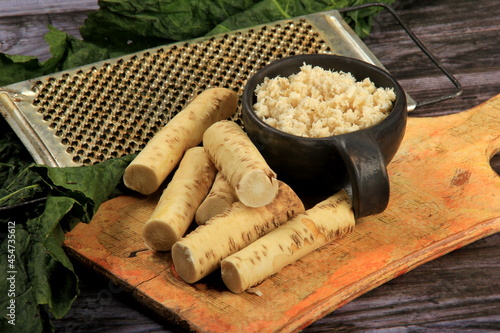 Fresh grated Horseradish roots on wooden table. The root of horseradish