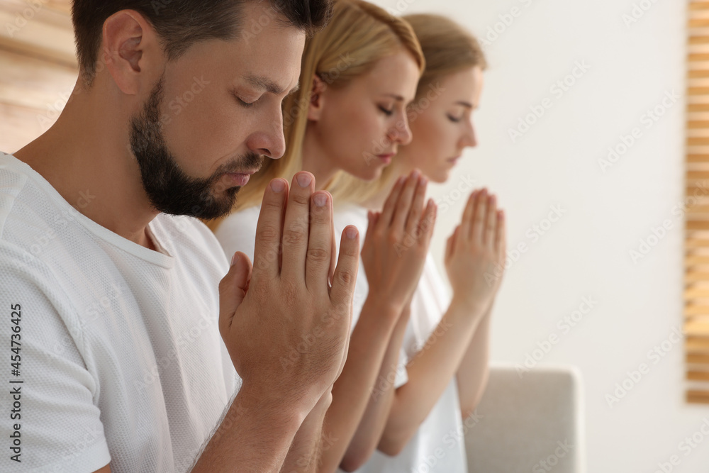 Group of religious people praying together indoors. Space for text Group of religious people praying together indoors. Space for text
