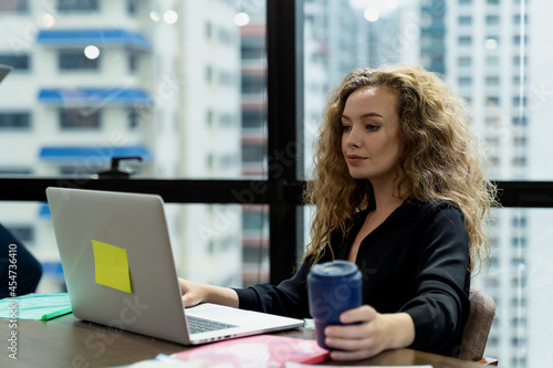 Free Download Business woman working with computer laptop on office desk in the office and city blur background - GFXLoad