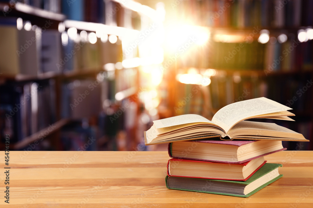 Fototapeta premium Many books on wooden table in library. Space for text