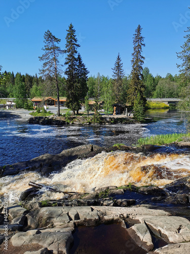 Side view of the Ahvenkoski waterfall on the Tokhmayoki River in Karelia on a clear summer morning. photo