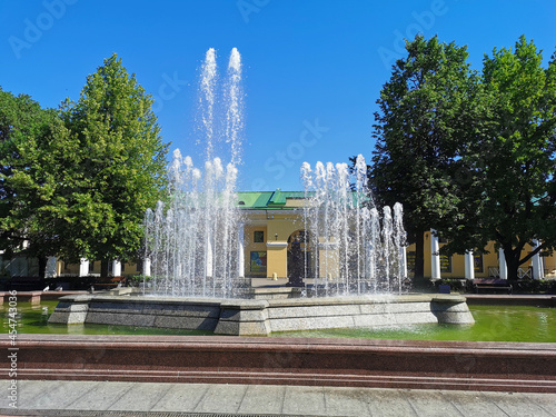 A singing fountain near the Gosin Courtyard, whose granite bowl resembles the contours of the Kronshlot fort in the city of Kronstadt against the background of a blue cloudless sky.