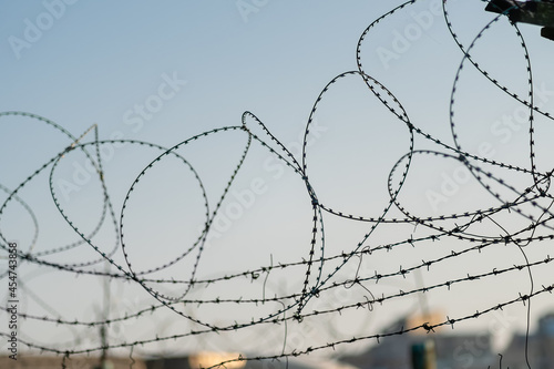 Barbed wire on the background of the sky at sunset close-up