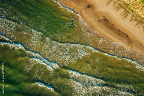 Aerial Top view shot of an empty sand beach Sand Sea Shore with a wave and white foamy, summer background