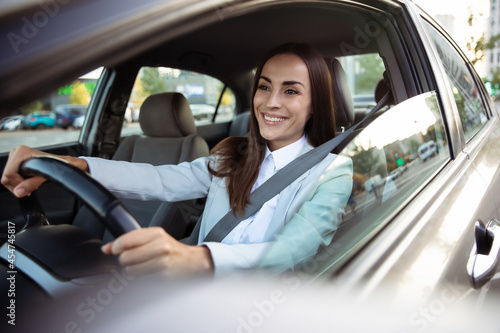 Portrait of cute female driver steering car with safety belt © My Ocean studio