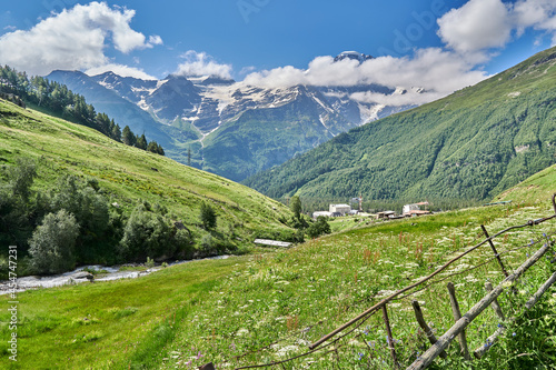 alpine green meadows in the mountains and snow-capped peaks