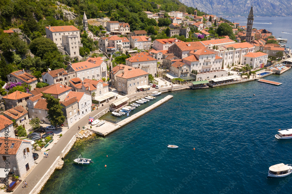 Perast, Boka Kotorska, Montenegro. Drone aerial view of small coastal town with old stone houses under the hills above the Adriatic Sea