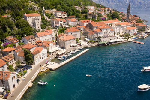 Perast, Boka Kotorska, Montenegro. Drone aerial view of small coastal town with old stone houses under the hills above the Adriatic Sea © Sliver