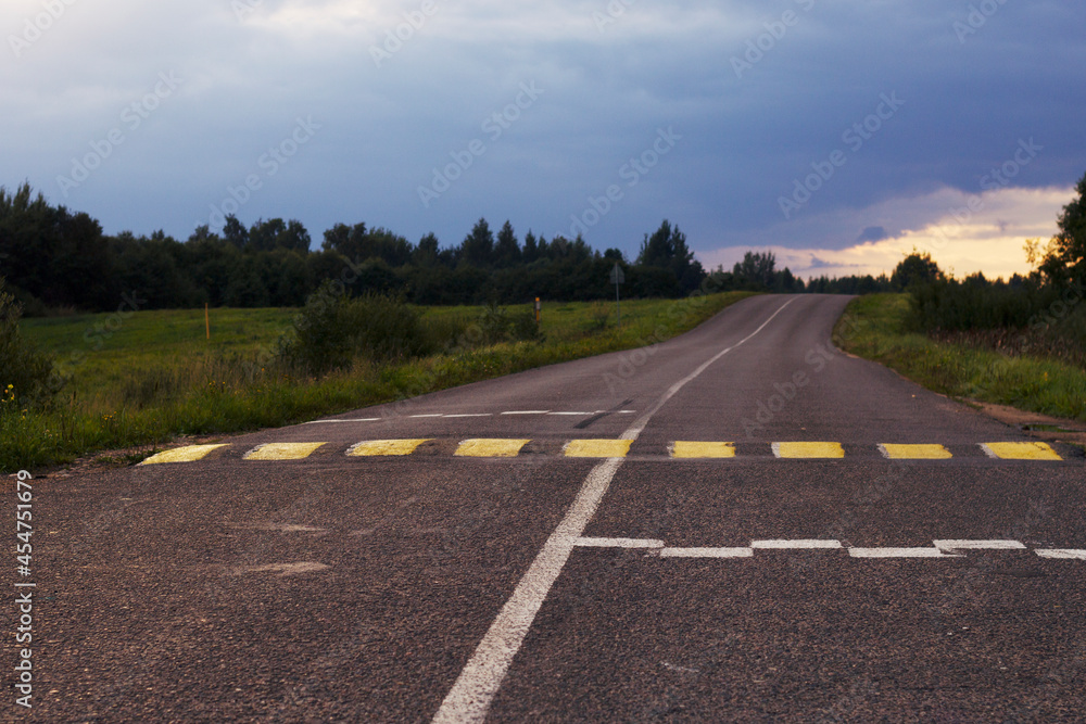 Contryside summer road in with yellow cross and and dark sky. Contryside summer road in with yellow cross and and dark sky.