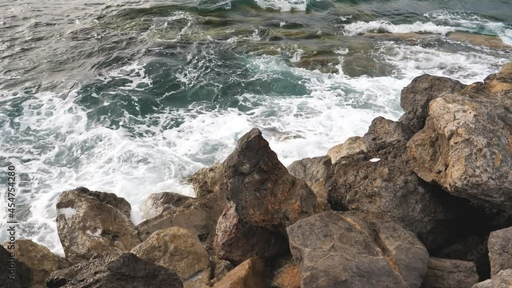 View of mediterranean waves splashing on the rocks in Port de Valldemossa, Mallorca, Spain View of mediterranean waves splashing on the rocks in Port de Valldemossa, Mallorca, Spain