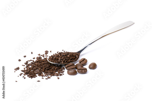 Instant coffee powder in steel spoon with roasted coffe beans isolated on white background.