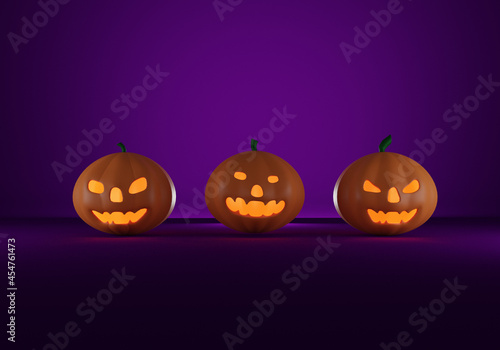 Three halloween pampkins on purple background. photo