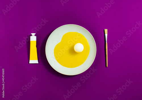Artistic egg, with yellow egg white and white yolk on a white plate with purple background. Minimal concept.