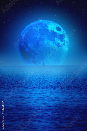 Full Moon rising above ocean horizon with boat silhouette.