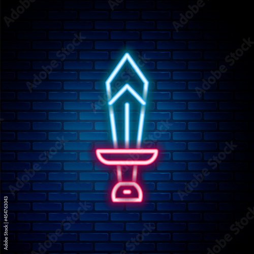 Glowing neon line Sword for game icon isolated on brick wall background. Colorful outline concept. Vector