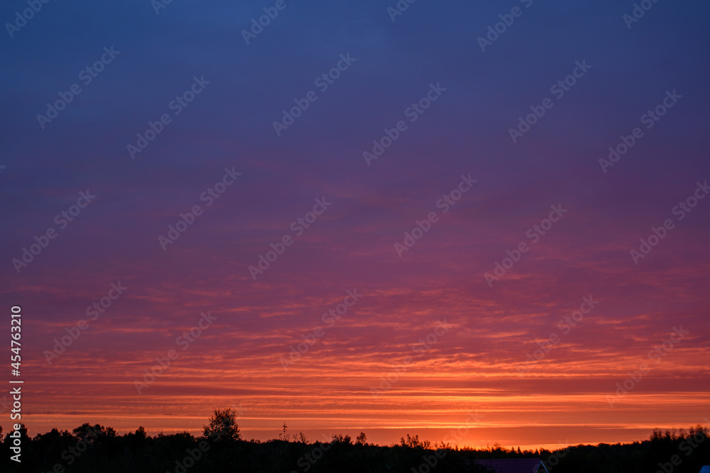 Sunrise turns the clouds pink and red