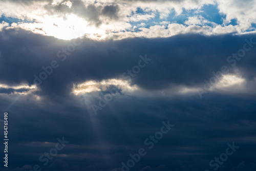 Rays of light shining throug dark clouds.Beautiful dramatic sky with sun rays.