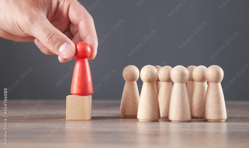 Male hand holding red wooden human figure. Leader Male hand holding red wooden human figure. Leader