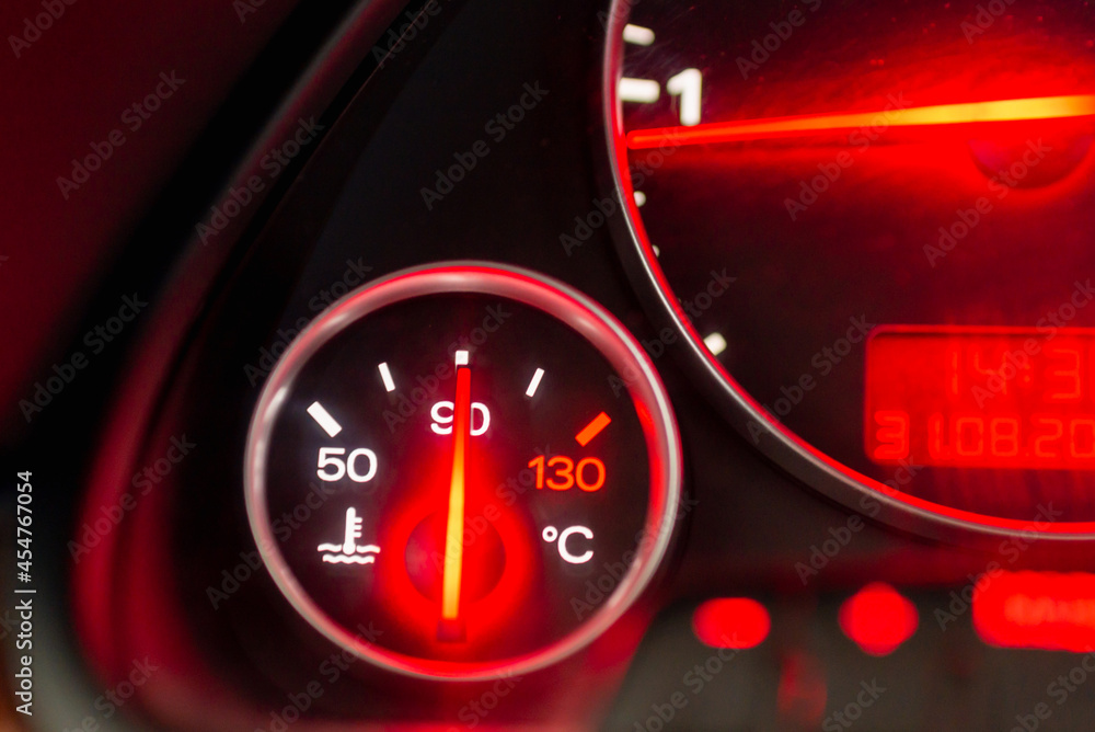 Car engine temperature sensor close up arrows.Lit red sign Overheating or norm of the motor on