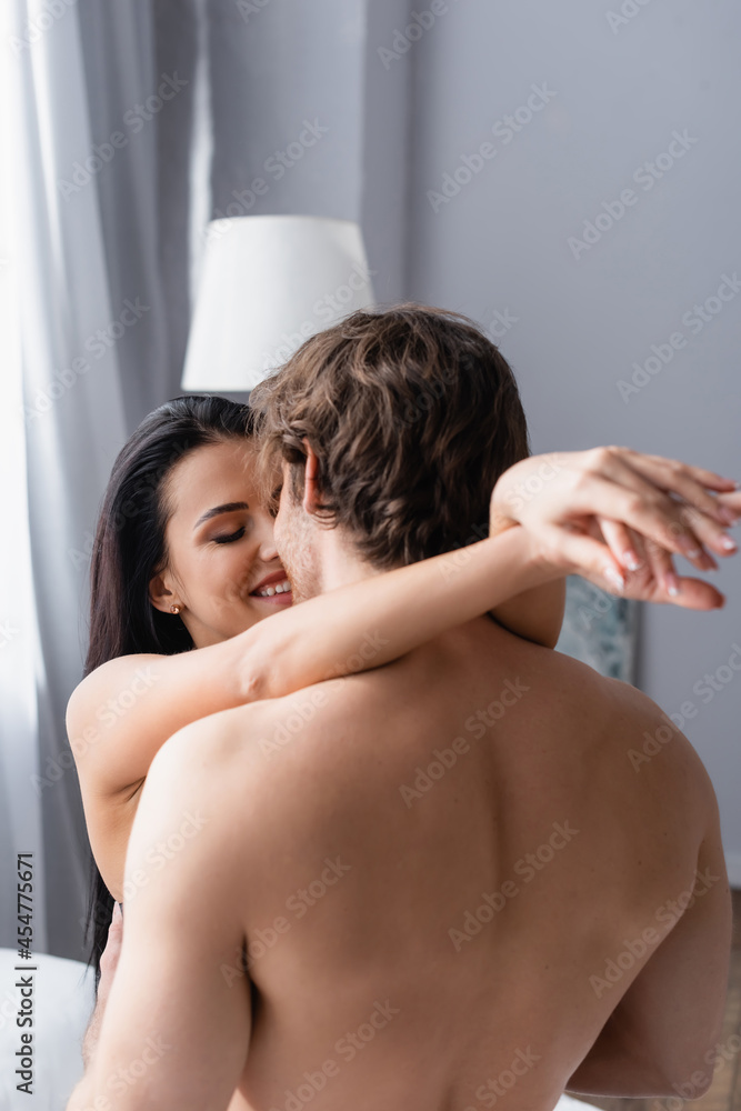 Obraz premium happy woman hugging shirtless man at home.
