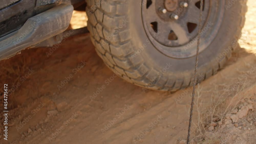 Closeup of the big wheel ofa suv that is driving on sandy clay terrain. Concept of traveling by car on the desert Closeup of the big wheel ofa suv that is driving on sandy clay terrain. Concept of traveling by car on the desert