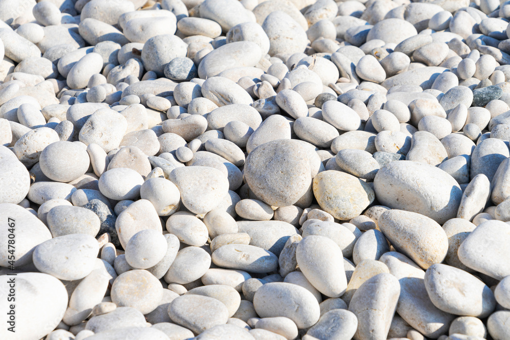 Small stone texture background. Pattern of white gray smooth seaside pebbles. Top view Small stone texture background. Pattern of white gray smooth seaside pebbles. Top view