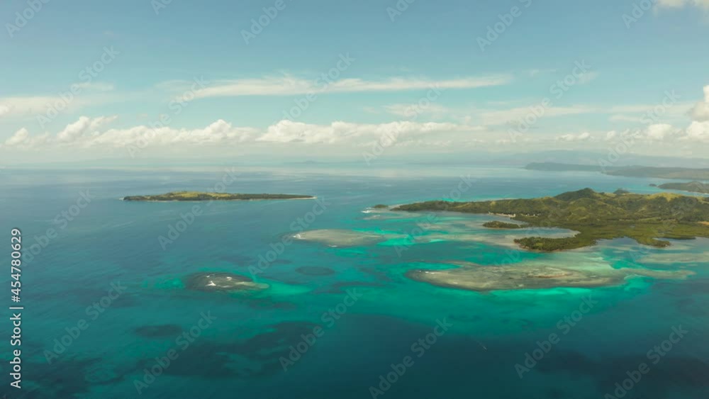 Aerial view of blue sea with atoll, islands and coral reef against the sky and clouds. Bucas grande, Philippines. Summer and travel vacation concept.