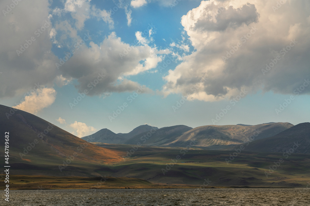 Beautiful landscape. Yellow hills mountains and small lake and blue sky. Beautiful landscape. Yellow hills mountains and small lake and blue sky.