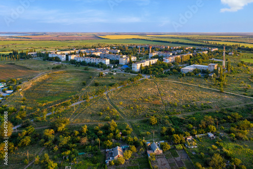 Aerial photography, a working village among the steppe fields in the light of the setting sun.