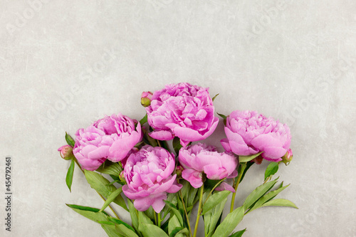 Bouquet of pink peonies flowers on light gray concrete background. Valentine's, womens, mothers day, easter, birthday or wedding, spring holiday flat lay. Top view. Copy space.
