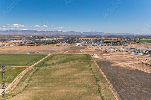 Farm fields with new construction and mountains of Boise