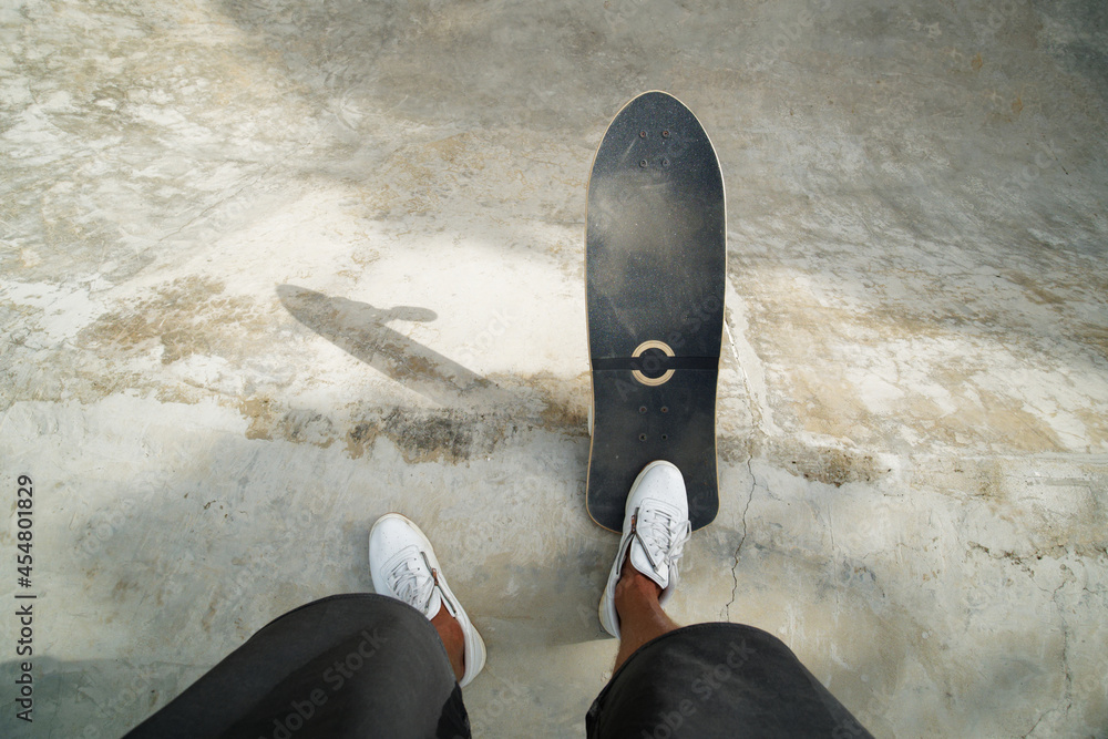 Foto Stock POV shot. Legs on Skateboard longboard in skate park with  concrete. | Adobe Stock