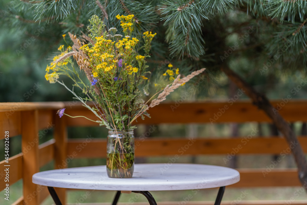 A bouquet of wildflowers in a jar on the table. A bouquet of wildflowers in a jar on the table.