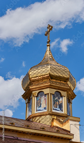 Golden dome of the church. Background of blue sky and white clouds.