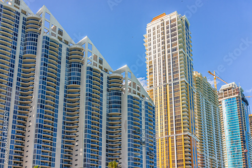 Sunny Isles Beach, USA apartment condo hotel building balconies during sunny day in Miami, Florida with skyscrapers and construction © Kristina Blokhin