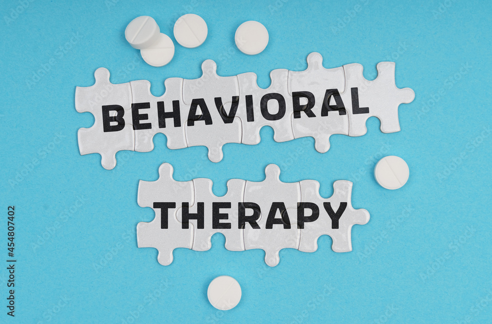 On a blue background pills and puzzles with the inscription - Behavioral Therapy On a blue background pills and puzzles with the inscription - Behavioral Therapy