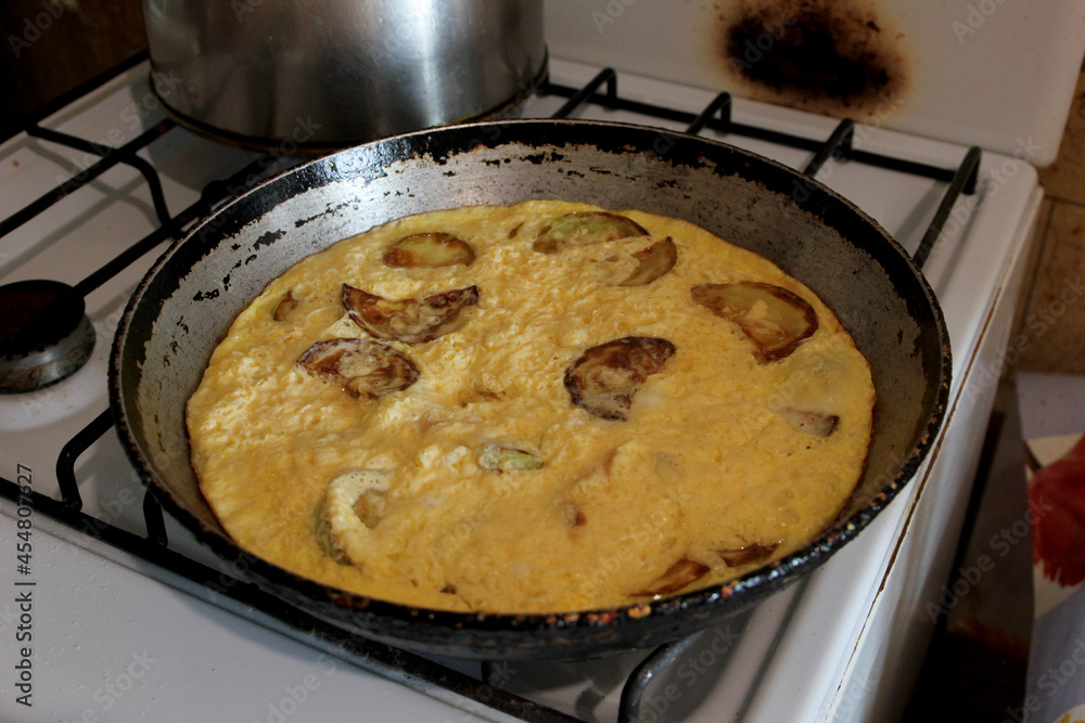 Cooked omelet with fried zucchini in a frying pan Cooked omelet with fried zucchini in a frying pan