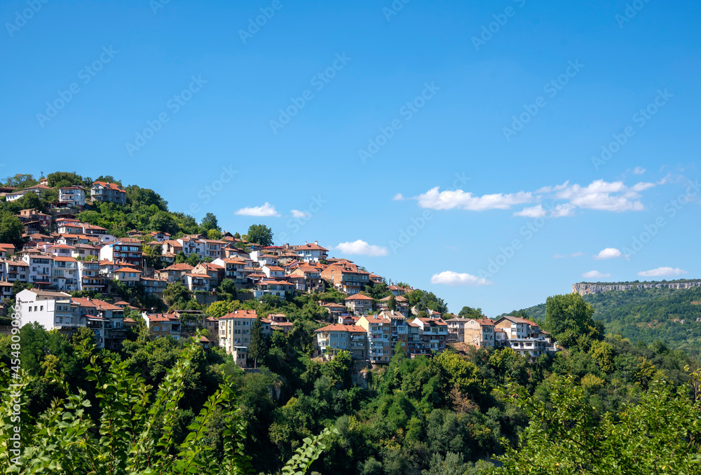 Houses with red tiled roofs , built on a mountain .