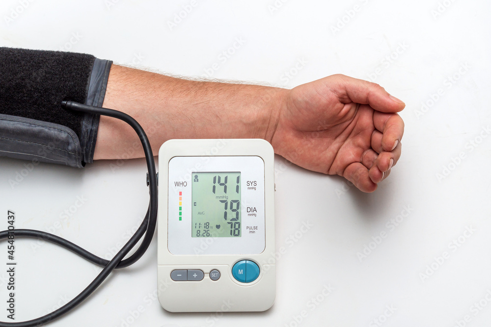 The person measures their own blood pressure at the medical table. Taking care of your own health The person measures their own blood pressure at the medical table. Taking care of your own health