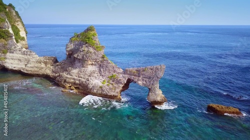 beautiful shot from drone above rock formation on the sea flying over tropical paradise beach in the island of Bali in Indonesia in exotic travel destination concept