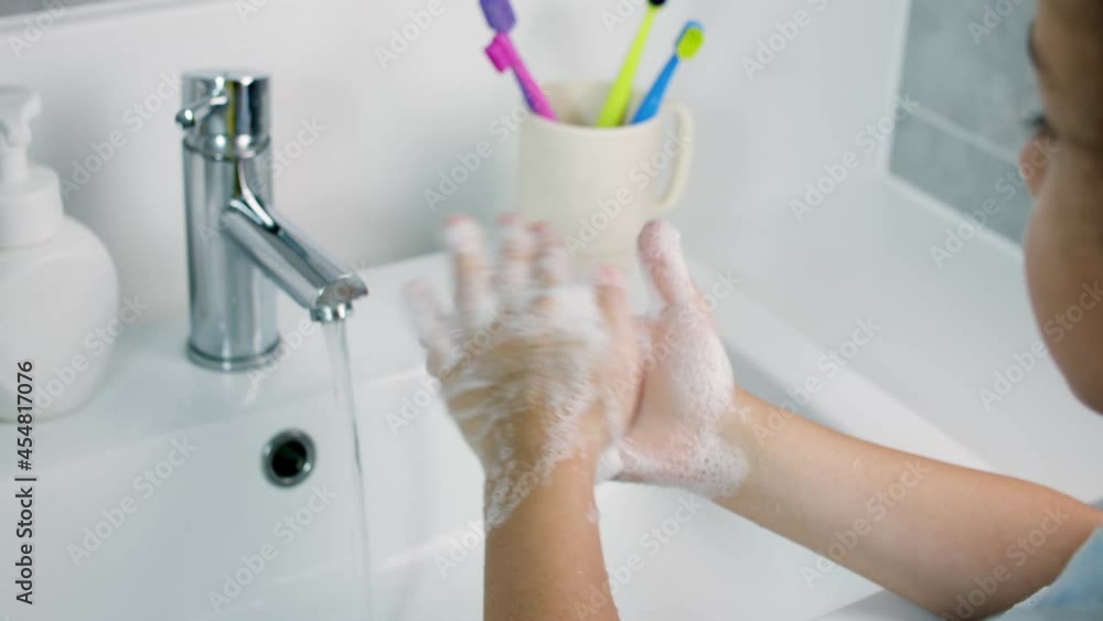 A child washes hands with soap, little girl Hands washing to prevention diffusion of virus and bacteria. Healthcare, Basic home hygiene.