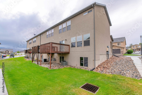 Exterior of a townhouse complex with wooden decks and backyard lawn photo